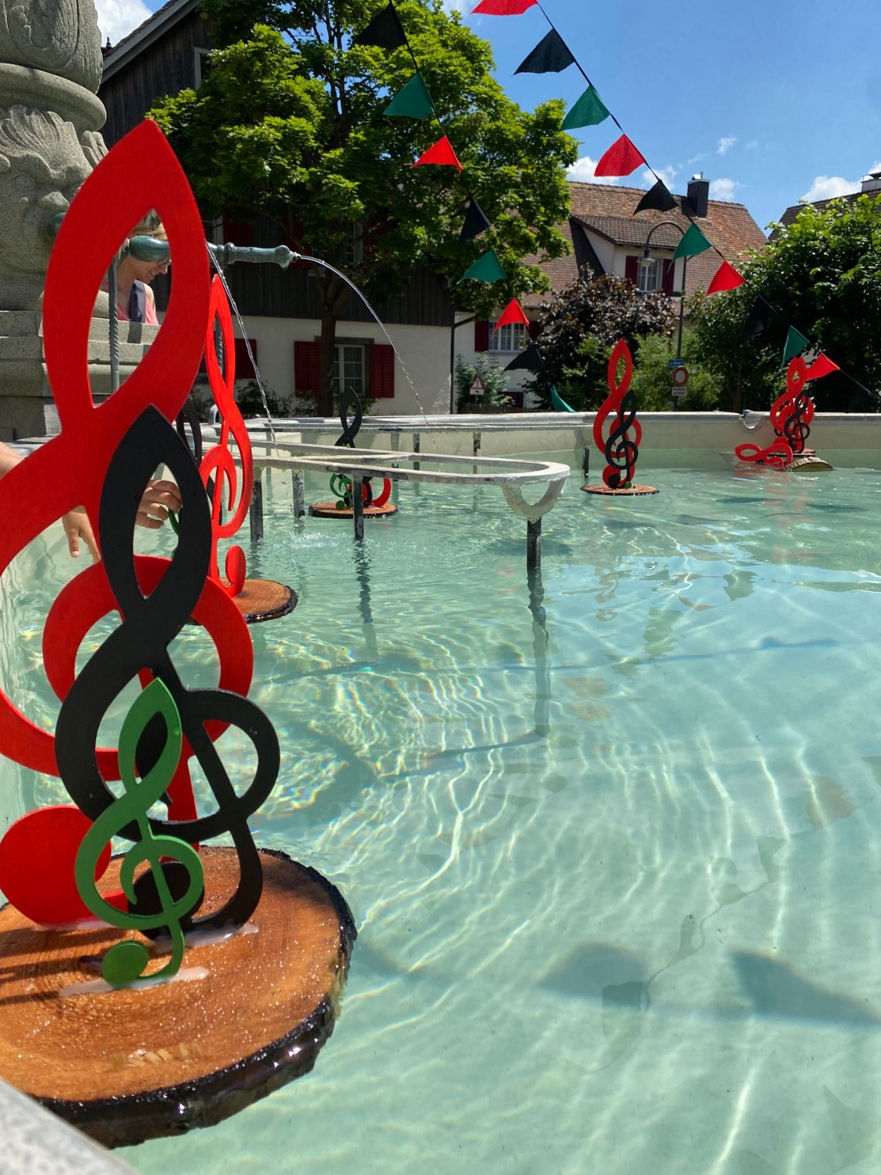 Geschmückter Brunnen in Thayngen mit schwimmenden Notenschlüsseln